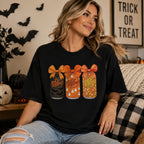 Female model wearing black Dr Pepper Halloween bow cans front-print graphic tee in a decorated fall living room