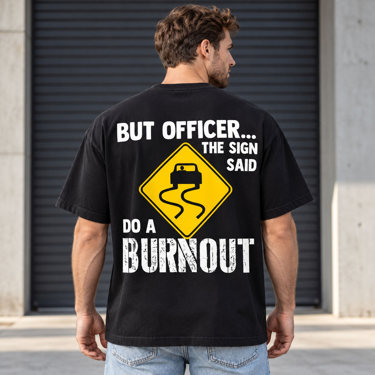 But Officer The Sign Said Do a Burnout yellow skidding-car sign graphic on black T-shirt back, adult model photo