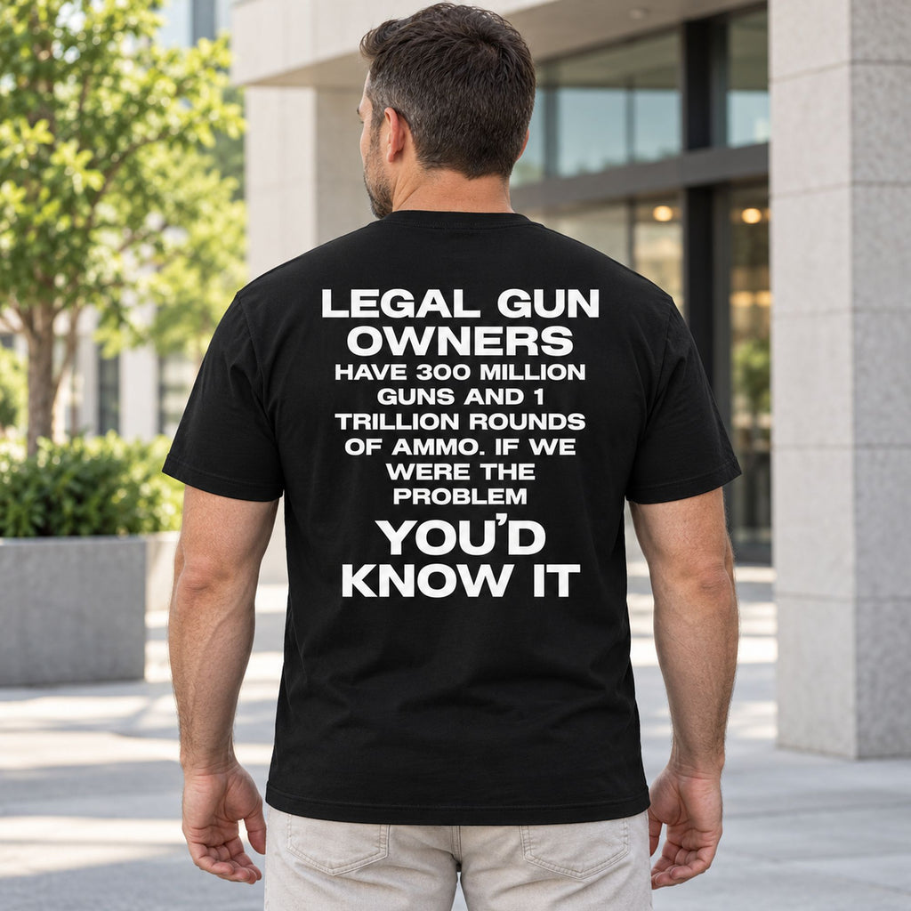 Legal Gun Owners statement back print on a black T-shirt, male model standing outdoors
