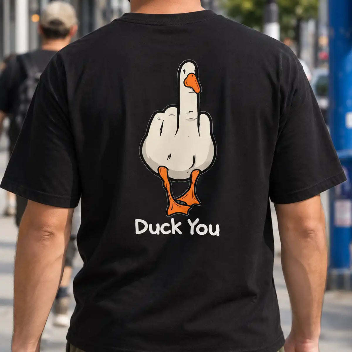 Duck You black T-shirt worn outdoors, showing the cheeky cartoon duck back graphic