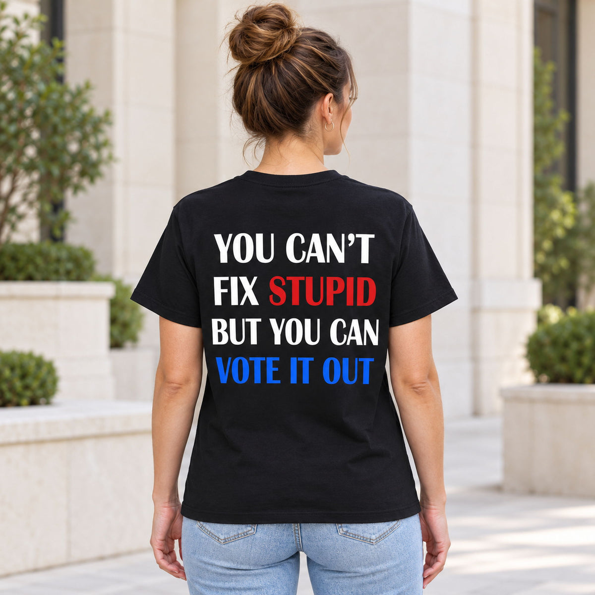 You Cant Fix Stupid But You Can Vote It Out red white blue slogan graphic on black T-shirt back, adult model photo