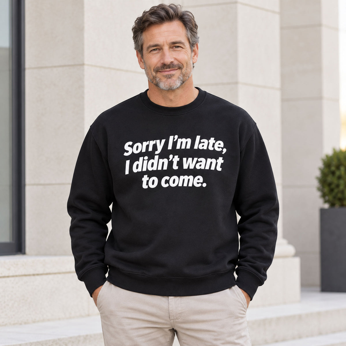 Sorry I’m Late sarcastic front print on a black sweatshirt, male model standing outdoors