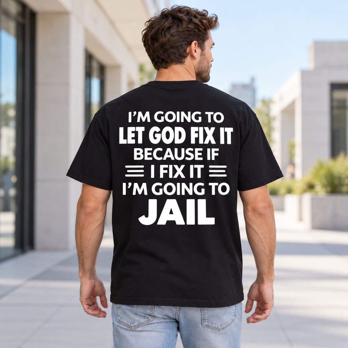 Let God Fix It Going to Jail joke lettering on black T-shirt back, adult male model outdoors
