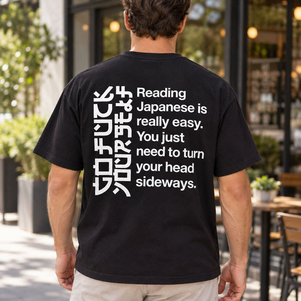 Black T-shirt back on a male model with angular sideways-reading artwork and Reading Japanese Is Really Easy lettering