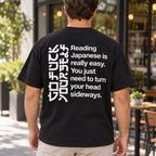 Black T-shirt back on a male model with angular sideways-reading artwork and Reading Japanese Is Really Easy lettering