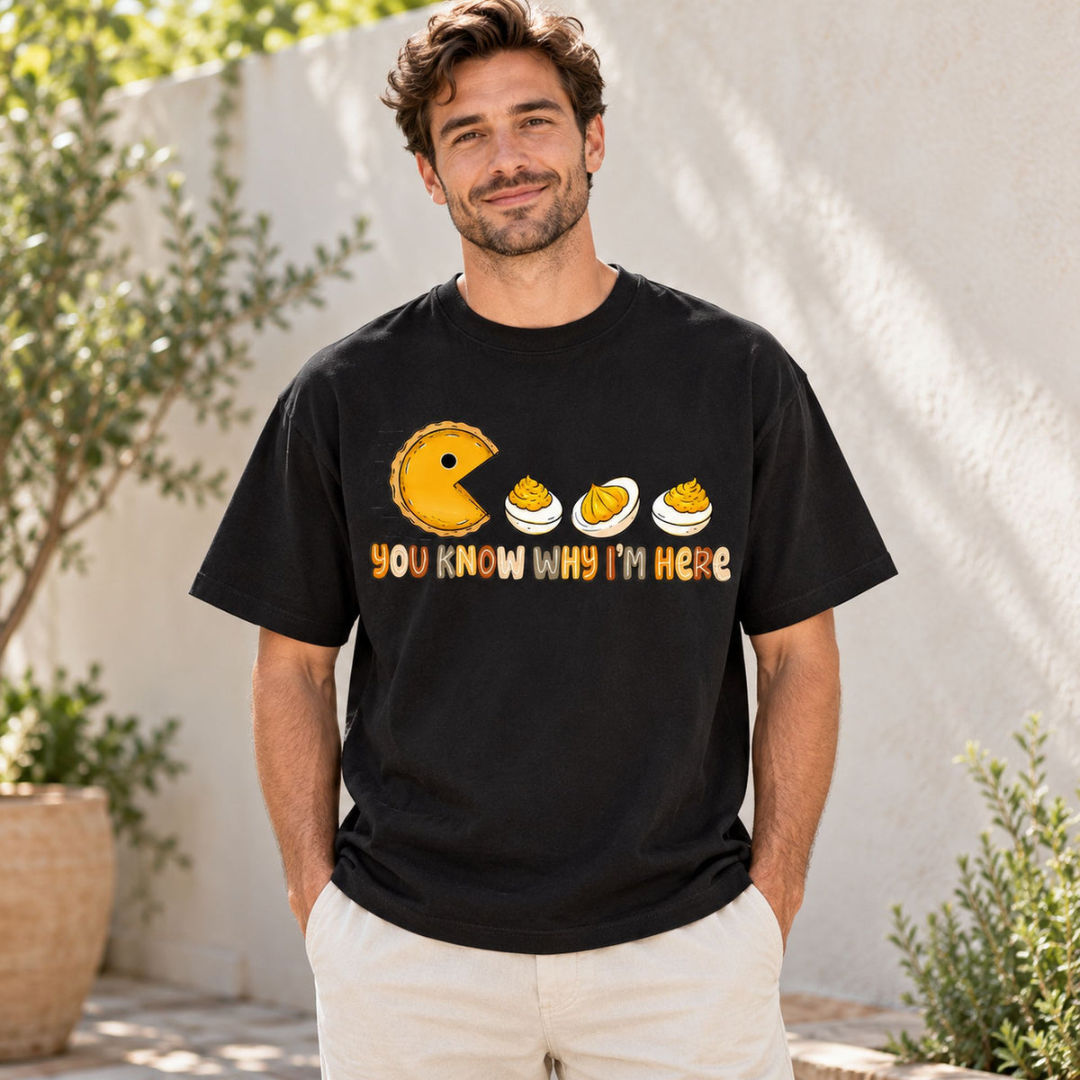 You Know Why Im Here deviled eggs and yellow chomping character graphic on black T-shirt front, adult model photo