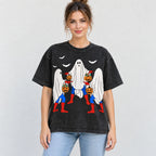 Halloween ghost trio and pumpkins front print on a black T-shirt worn by a female model