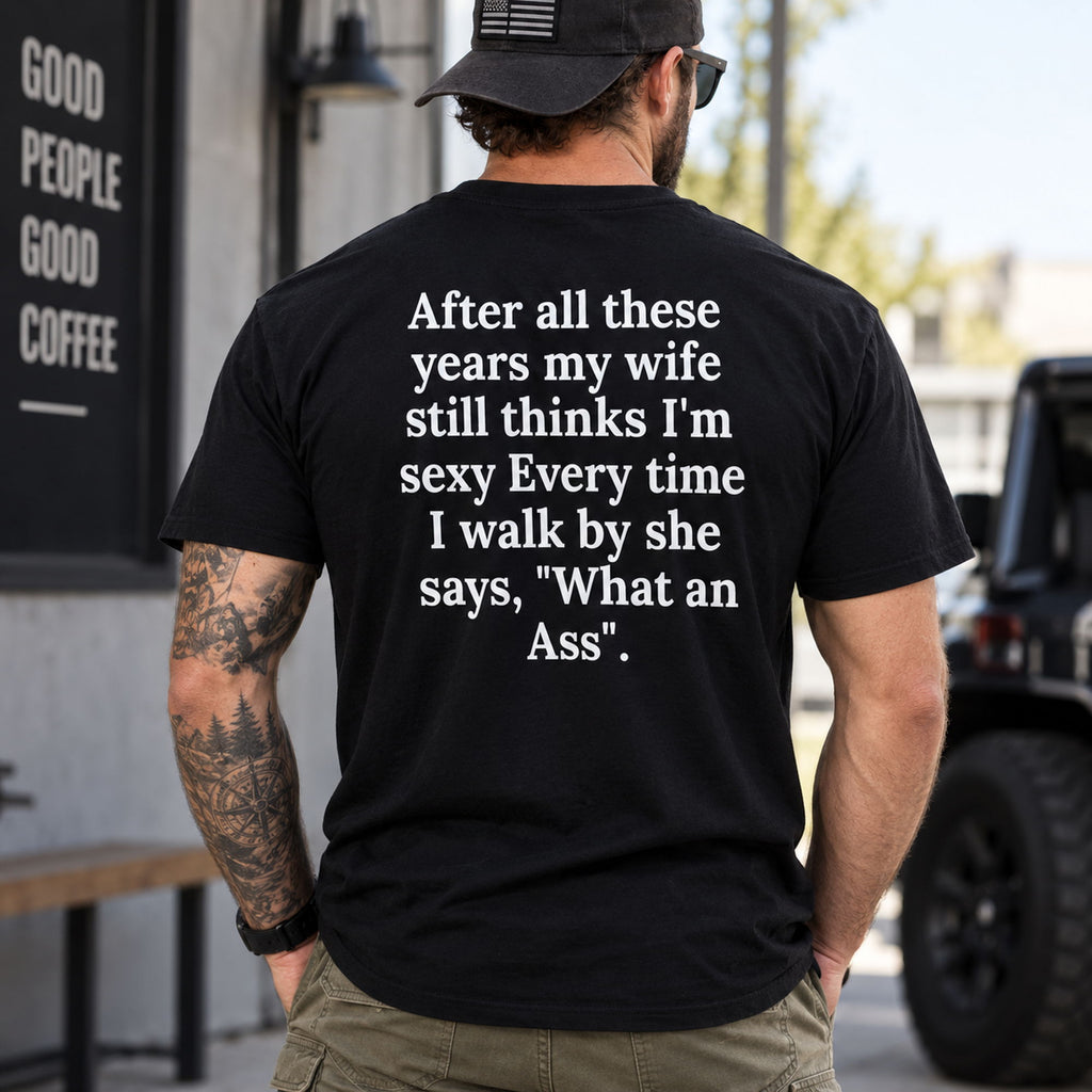 After All These Years My Wife funny black T-shirt, model wearing the large back quote outdoors