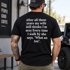 After All These Years My Wife funny black T-shirt, model wearing the large back quote outdoors