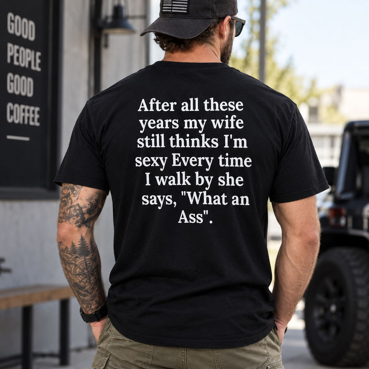 After All These Years My Wife funny black T-shirt, model wearing the large back quote outdoors