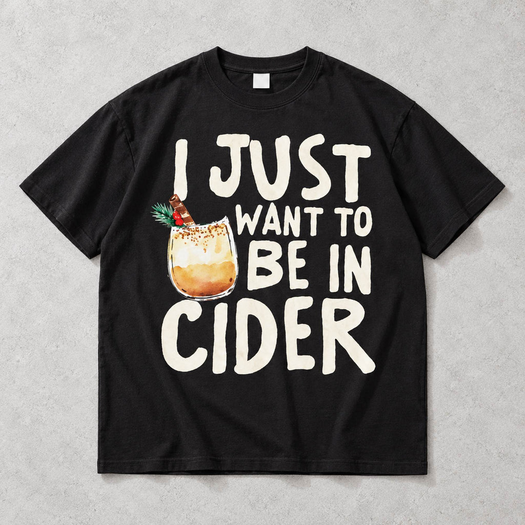 I Just Want to Be in Cider Christmas drink graphic on black T-shirt front, flat lay