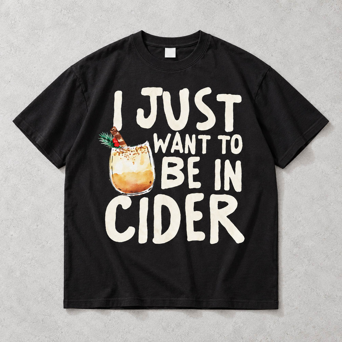 I Just Want to Be in Cider Christmas drink graphic on black T-shirt front, flat lay