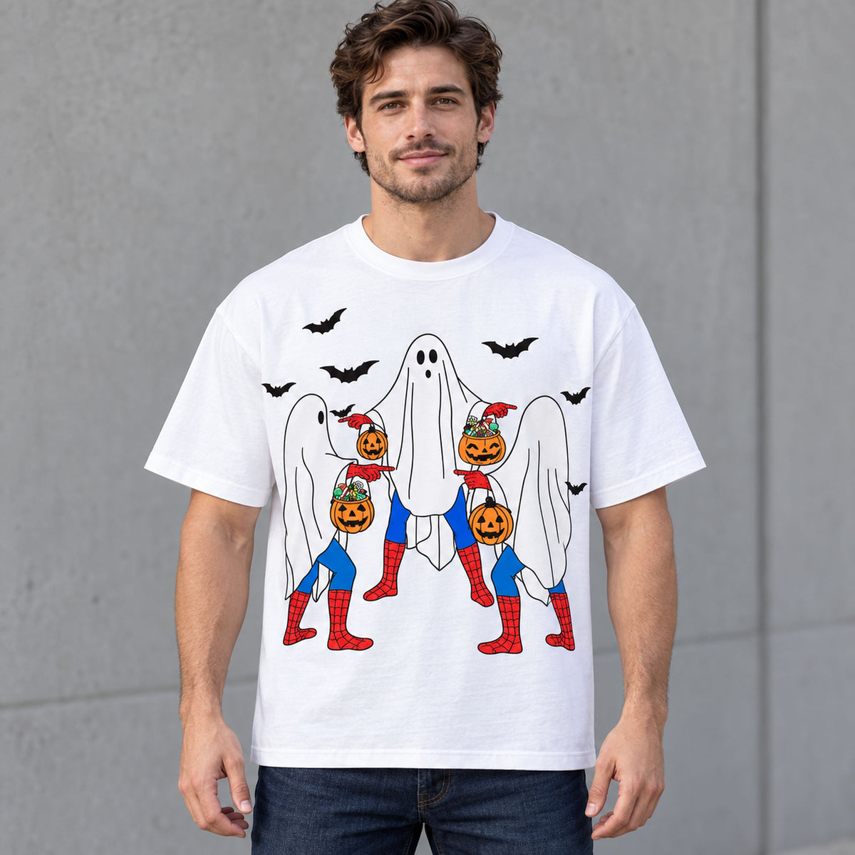 Halloween ghost trio and pumpkins front print on a white T-shirt worn by a male model