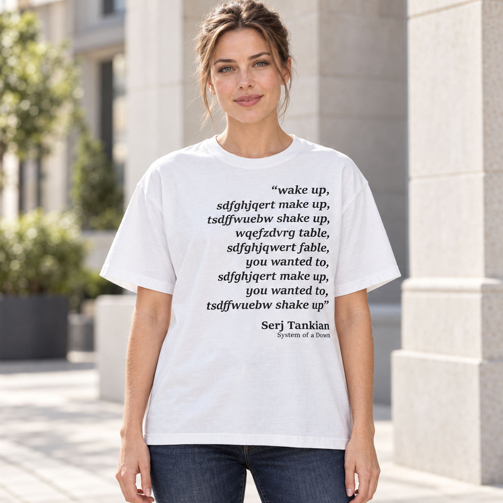 White tee front on an adult female model with Wake Up scrambled text and Serj Tankian attribution