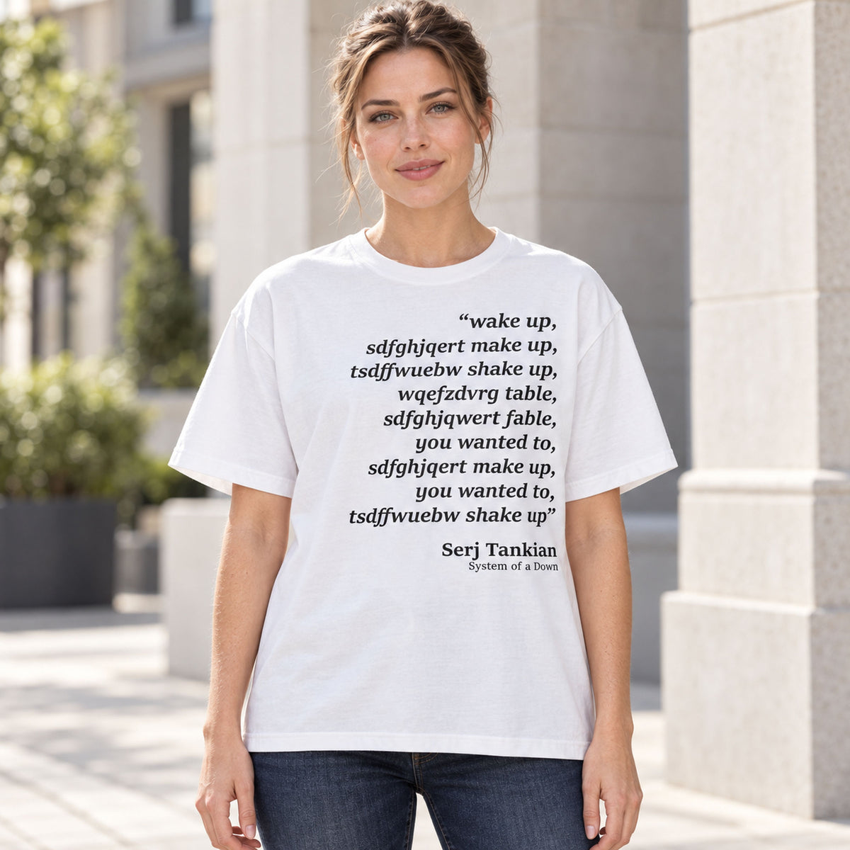 White tee front on an adult female model with Wake Up scrambled text and Serj Tankian attribution