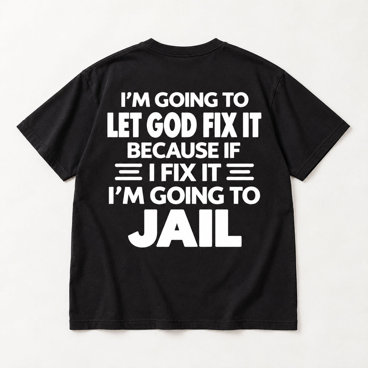 Let God Fix It Going to Jail large white lettering on black T-shirt back flat lay