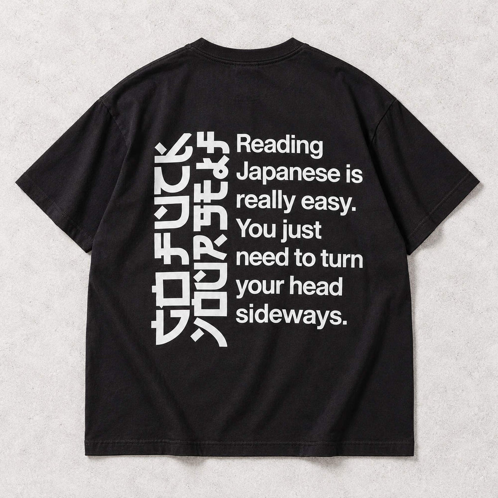 Black T-shirt back flat lay with the complete Reading Japanese Is Really Easy sideways-reading print