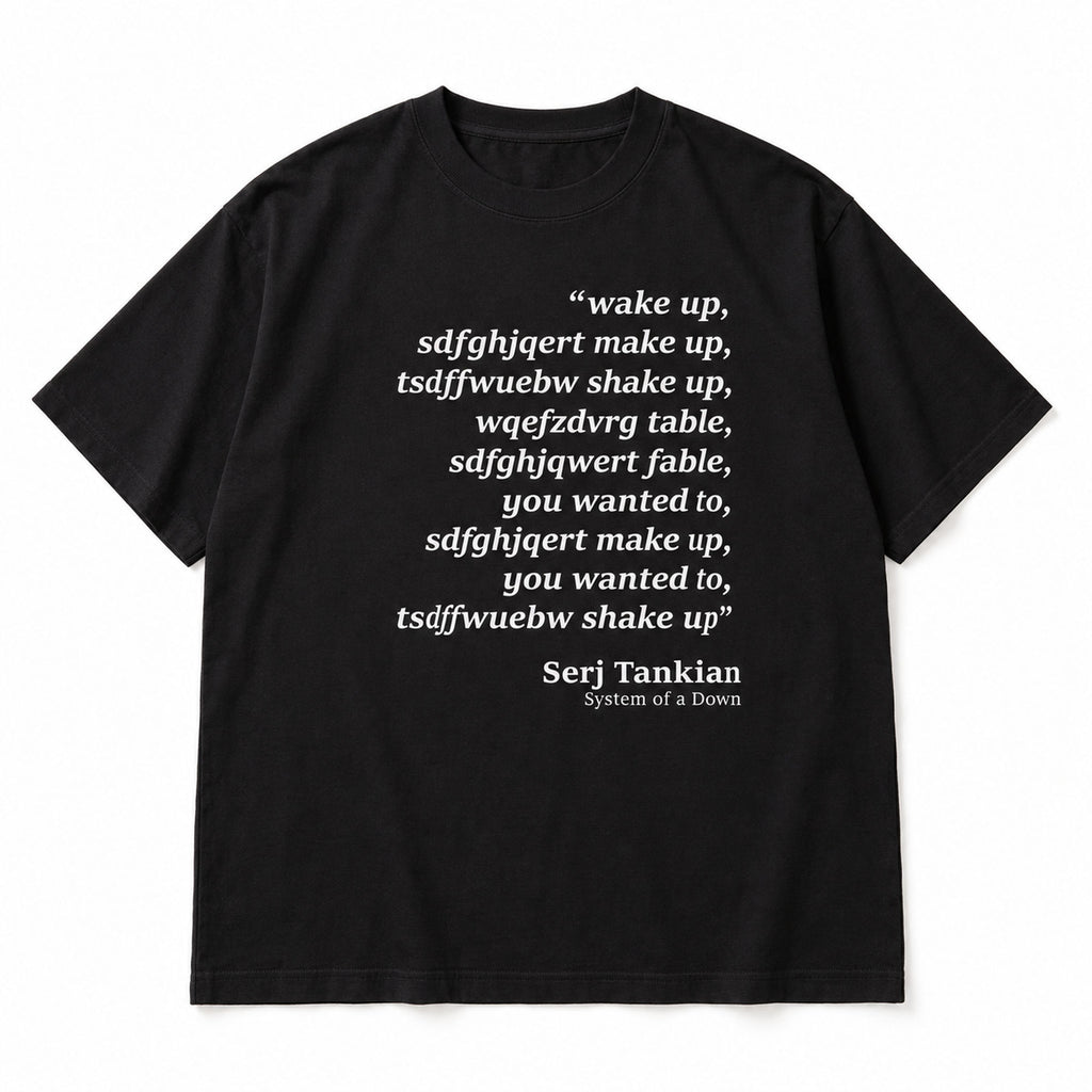 Black tee front flat lay with Wake Up scrambled text and Serj Tankian attribution