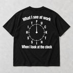 Black graphic tee back flat lay with What I See At Work lettering design