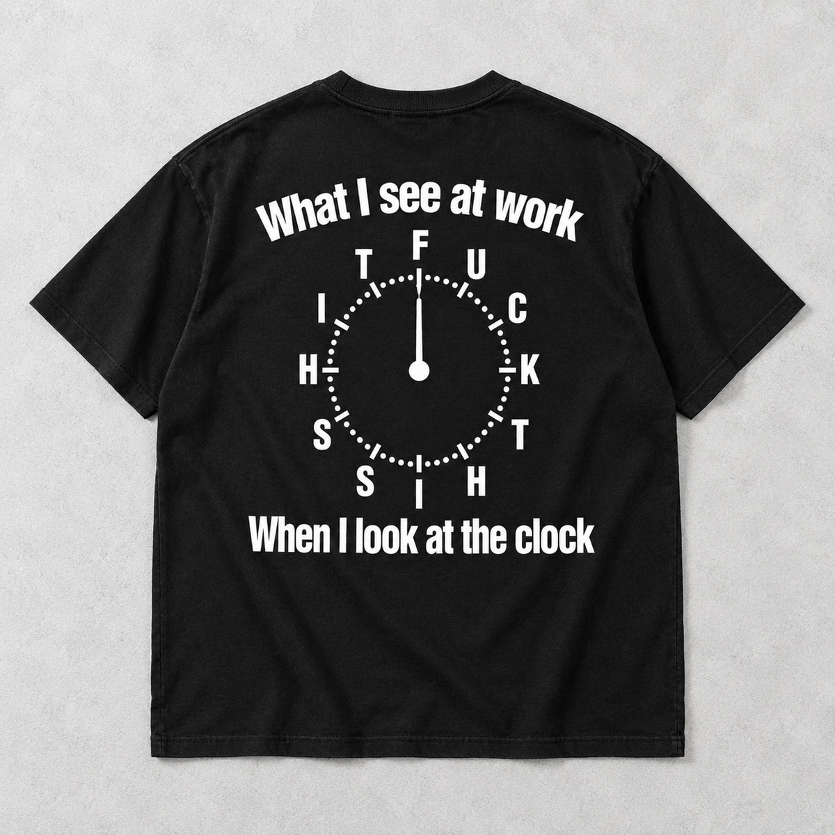 Black graphic tee back flat lay with What I See At Work lettering design