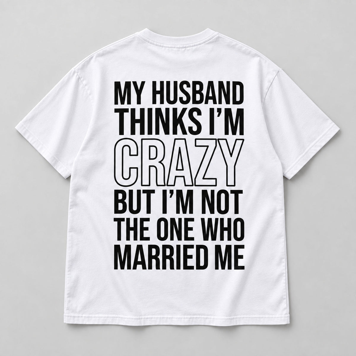 White marriage humor graphic T-shirt laid flat from the back with black lettering and the Married Me punchline