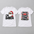 White Christmas couple graphic tees in a front flat lay, with Santa on the men's design and festive ornaments on the women's design