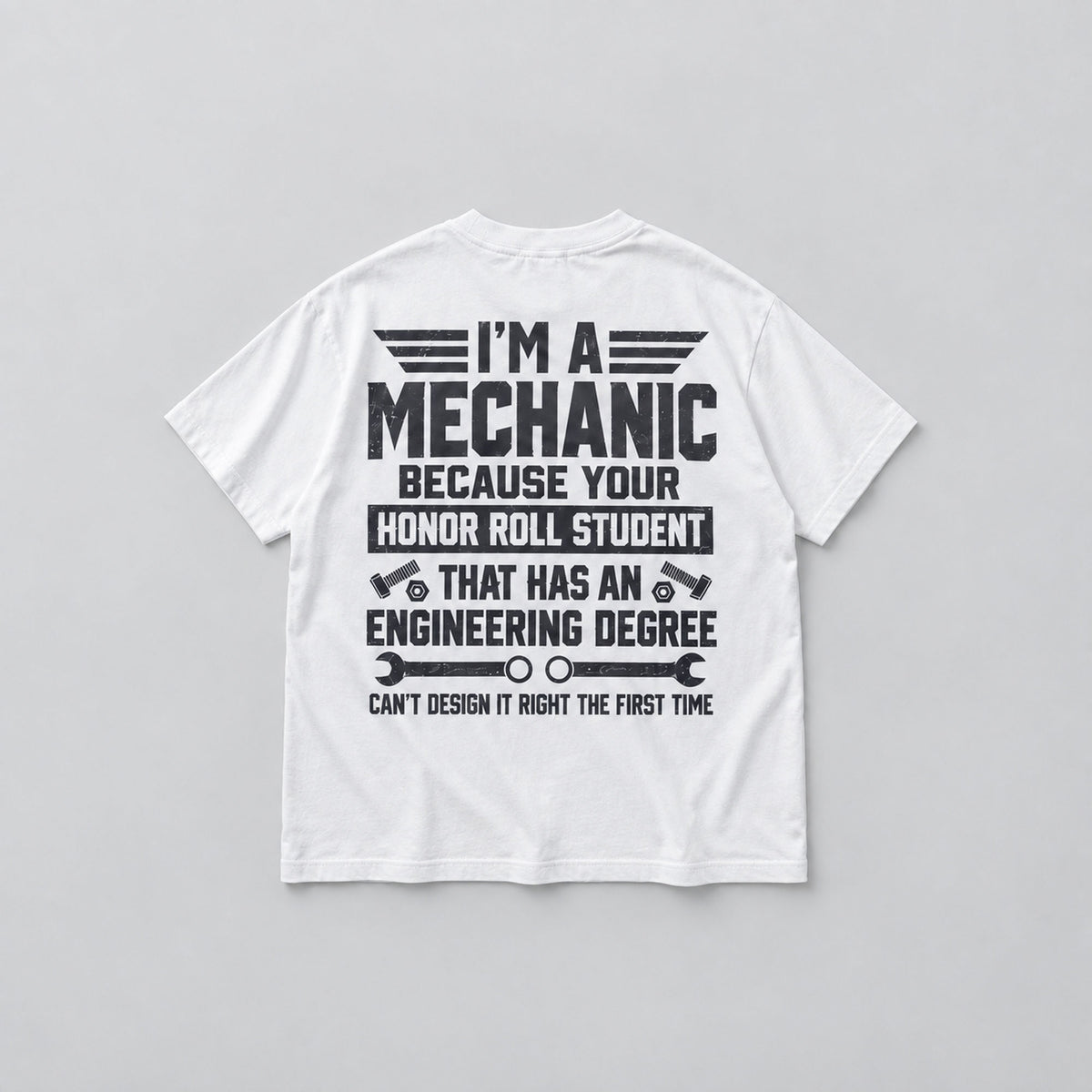 White I'm A Mechanic back-print graphic T-shirt, flat lay showing dark slogan and mechanic tools
