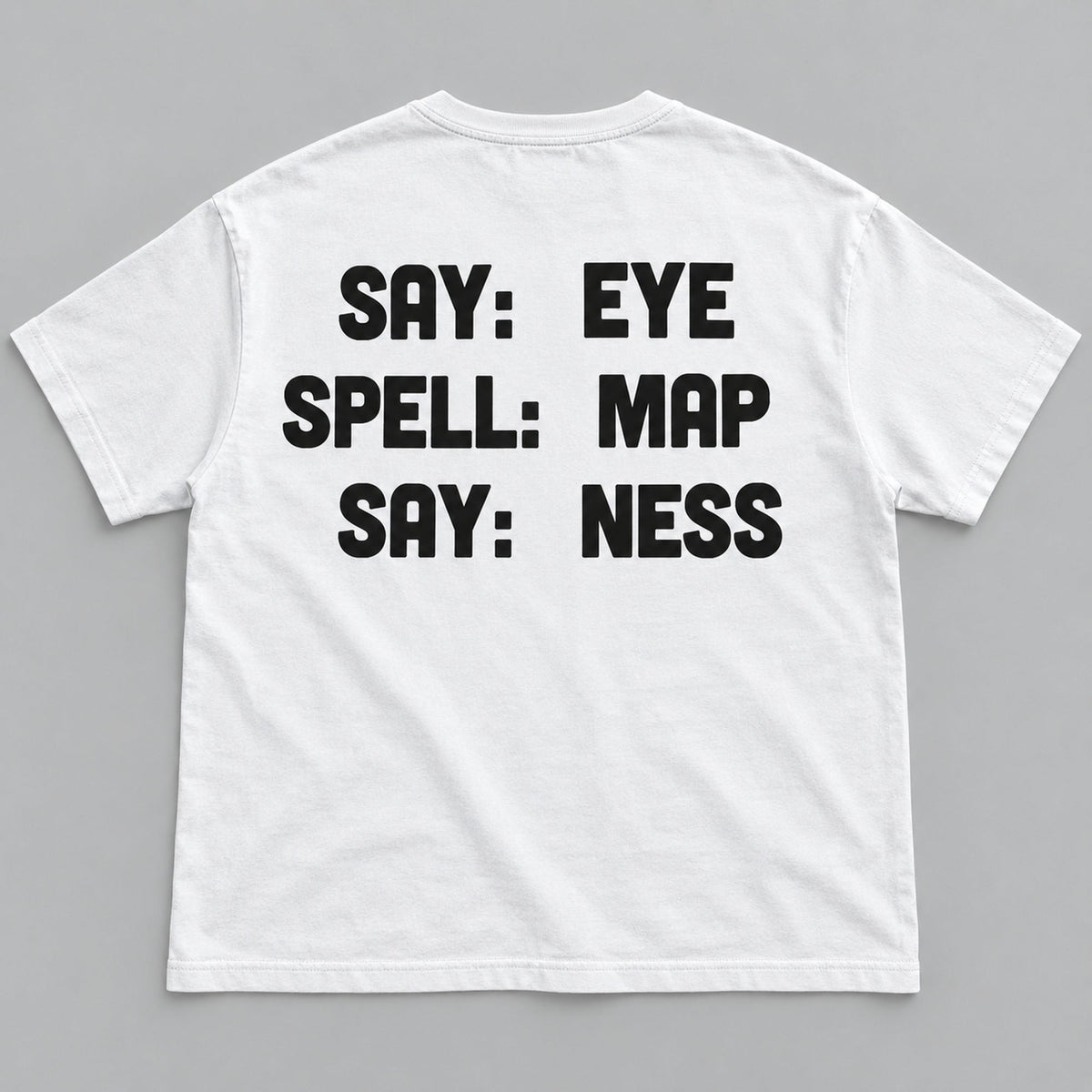 Say Eye Spell Map Say Ness black lettering on a white T-shirt back flat lay against a grey background