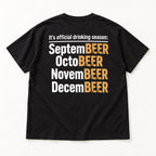 Official Drinking Season white and gold lettering on black T-shirt back flat lay, closer view