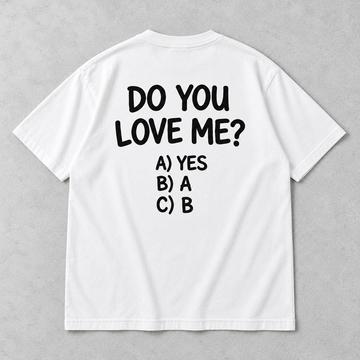 White graphic tee back flat lay with Do You Love Me design