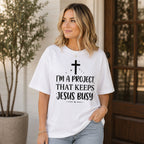 I'm A Project That Keeps Jesus Busy Faith Graphic Tee front print product photo 01 | Diya Glow