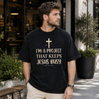 I'm A Project That Keeps Jesus Busy Faith Graphic Tee front print product photo 04 | Diya Glow