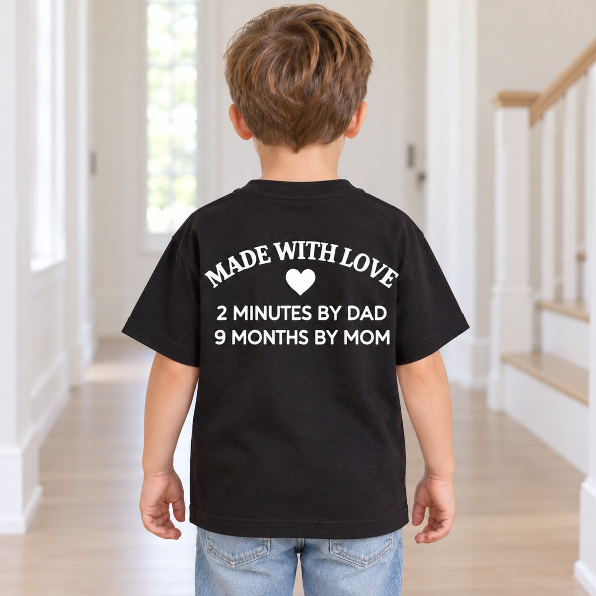 Made With Love kids black T-shirt with white family joke back print on a child model