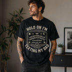 Male model wearing black Hold On I'm Texting My Dad Ouija board graphic tee, front view