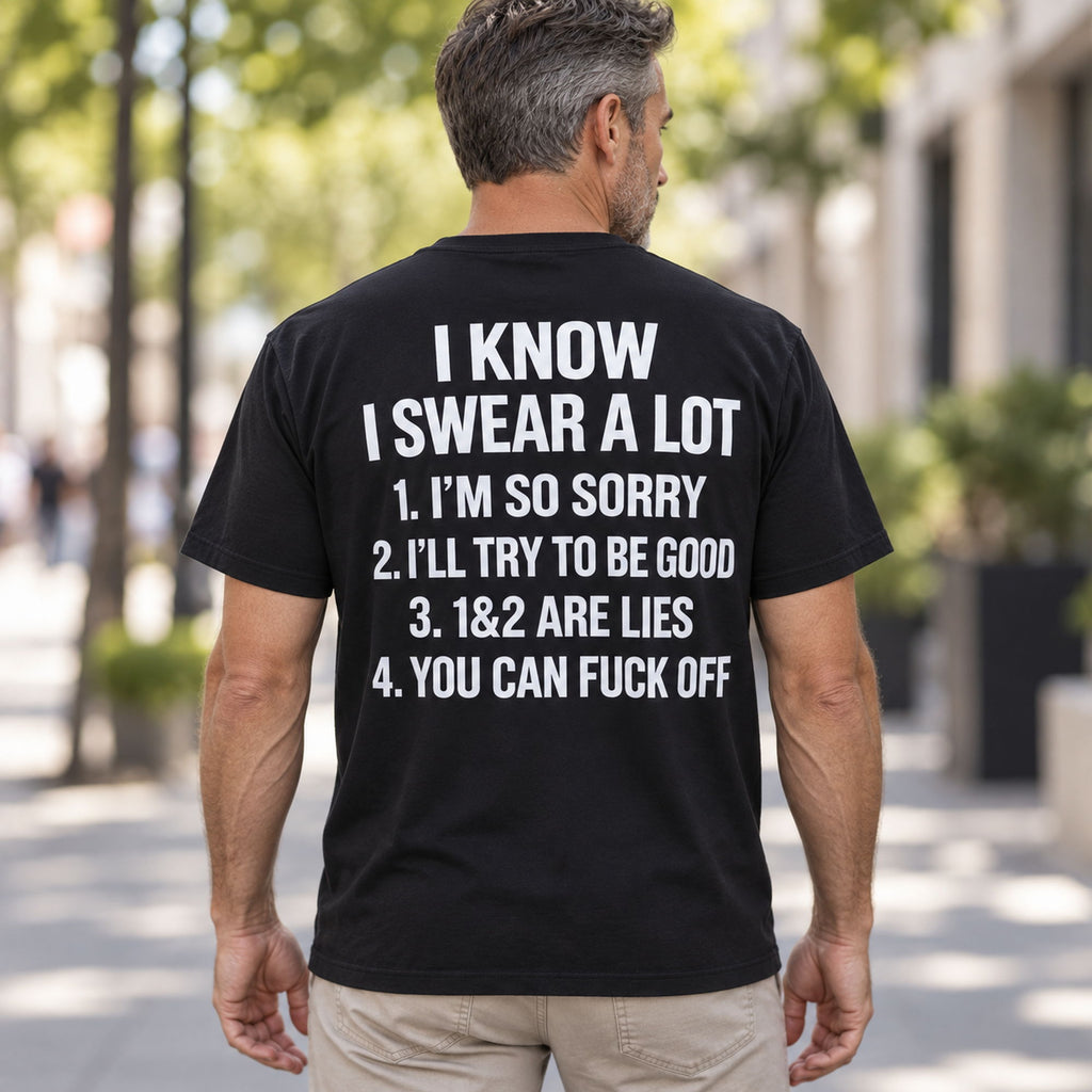 I Know I Swear A Lot funny graphic T-shirt in black with white back lettering, worn by a male model on an outdoor walkway