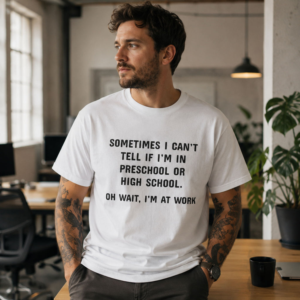 White funny work graphic tee with black preschool-or-high-school slogan on male model in office