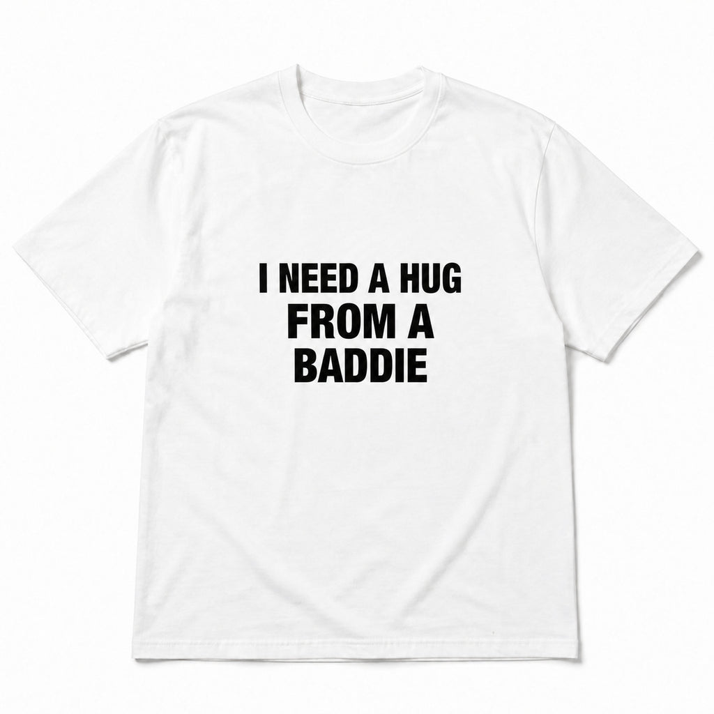 White I Need a Hug From a Baddie funny front-print graphic tee, front flat lay on white background