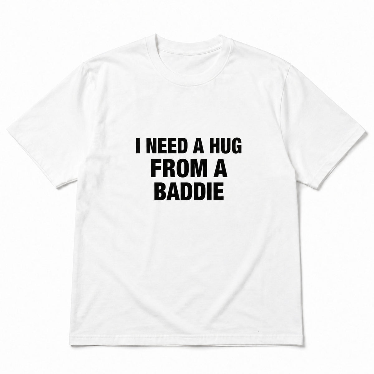 White I Need a Hug From a Baddie funny front-print graphic tee, front flat lay on white background