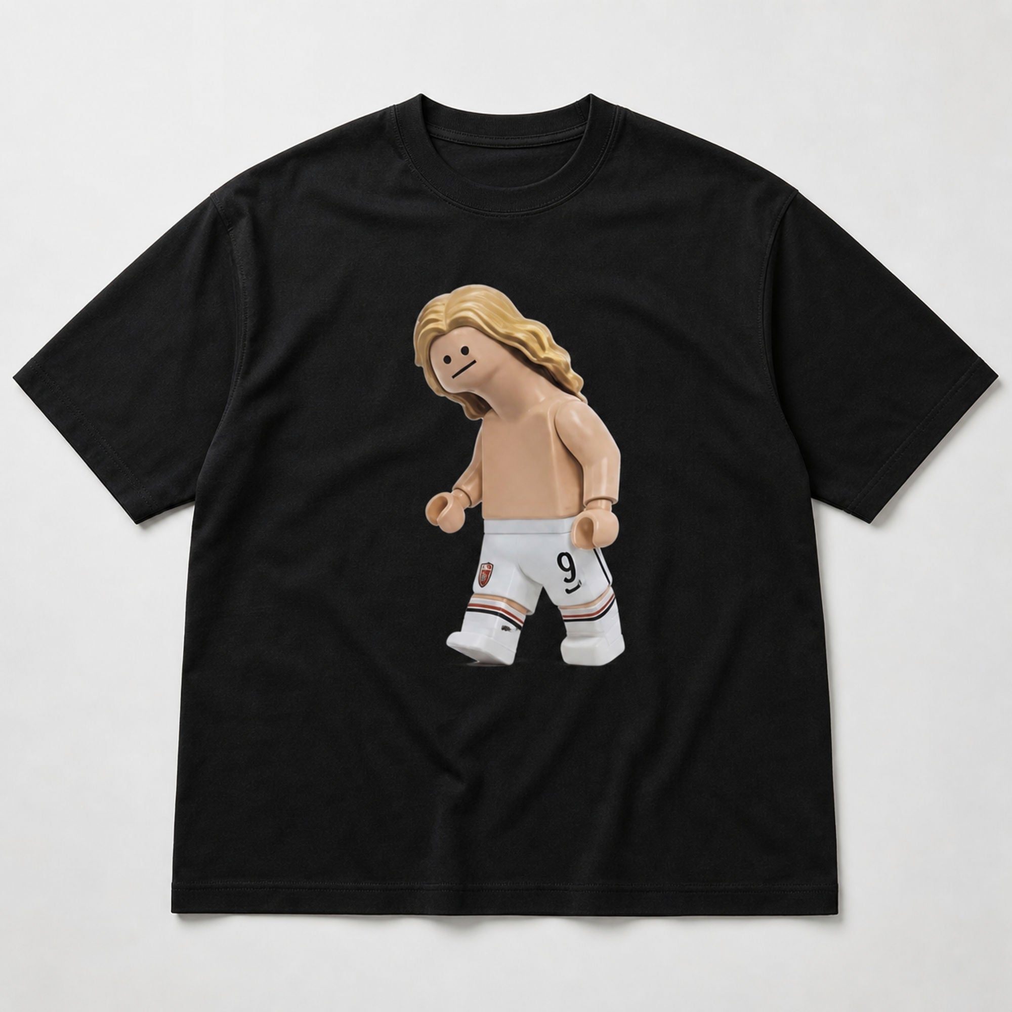 Blond number nine toy striker football graphic centered on black T-shirt flat lay